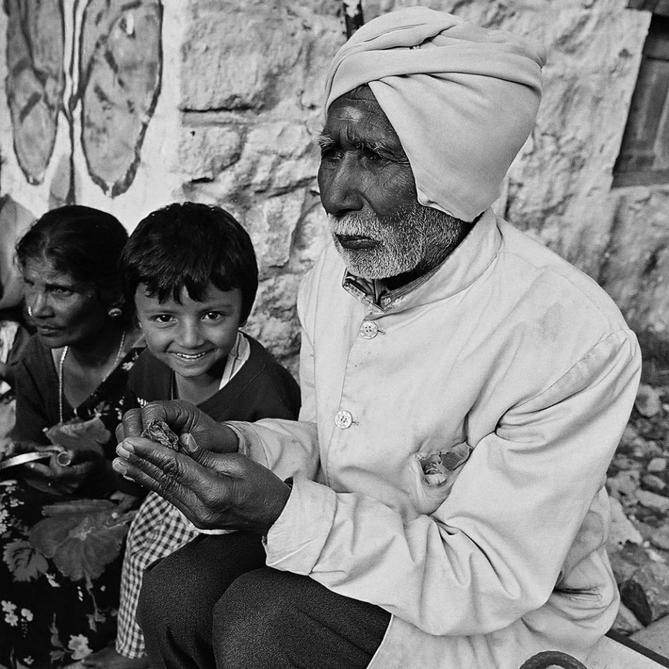 In the mountains, at Kodaikanal, an elderly gentleman rolls up a bit of betel nut for a chew.