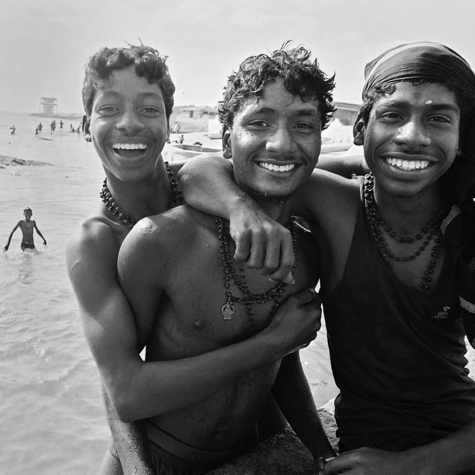 Happy young men pose for the camera at the beach in  Kanyakumari, India 2003